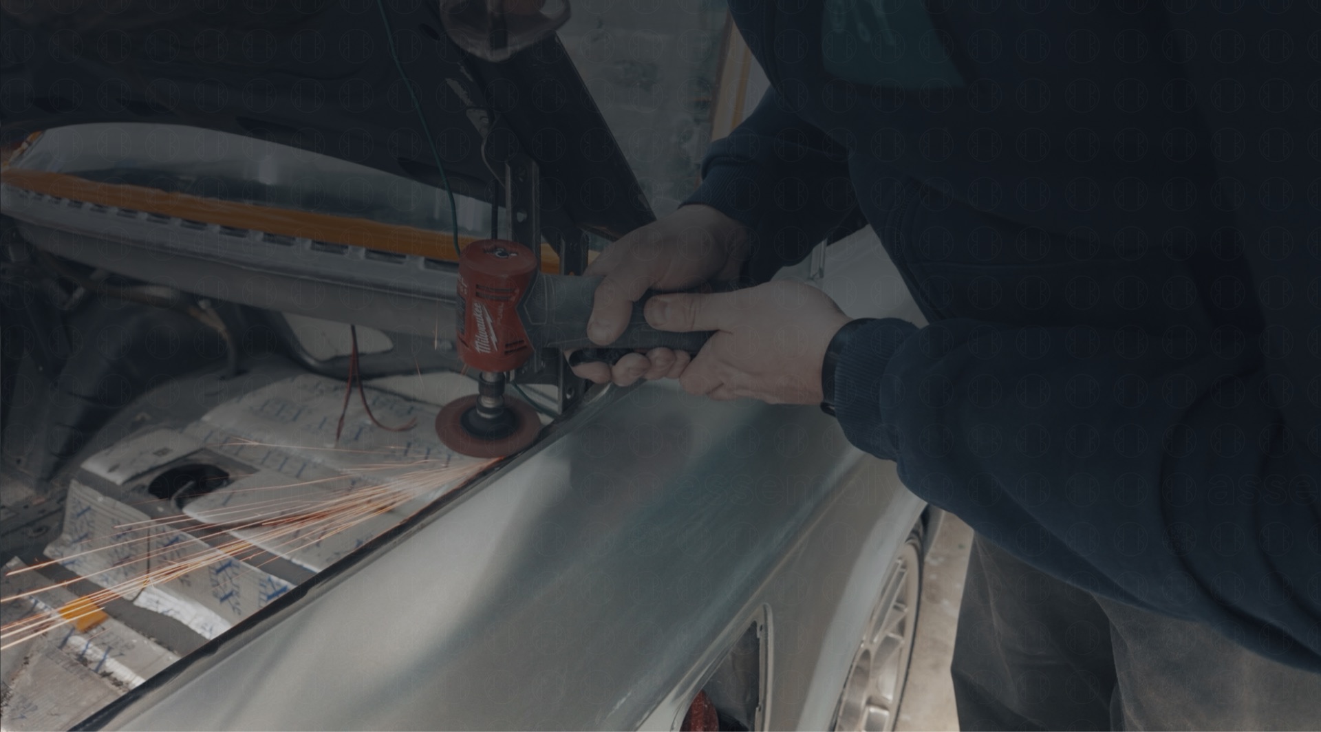 Working on a project car with an angle grinder in the garage
